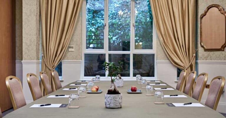 Room set up for a conference with paper, pens and apples on table