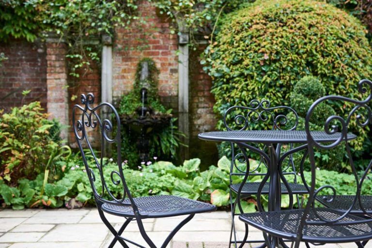Courtyard garden with water feature and small table and chairs set