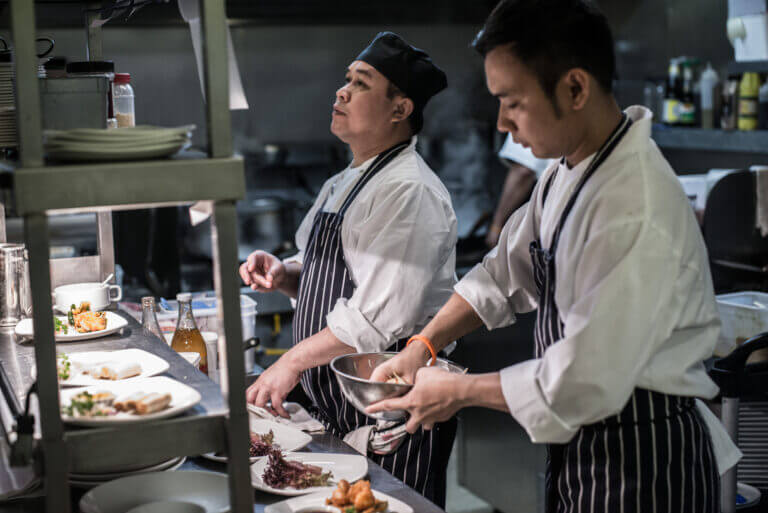 Chefs working on orders in Zen Garden restaurant kitchen at Careys Manor Hotel
