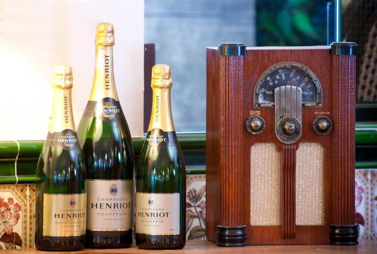 Three bottles of champagne next to old classic radio
