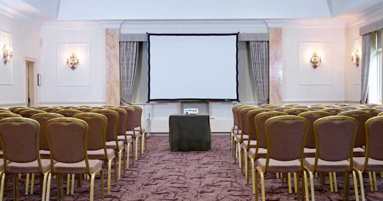 Room set up for a conference with large projector screen