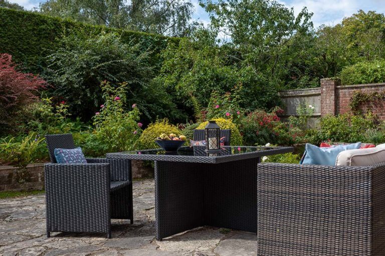 Pittefaux Cottage Garden at Careys Manor Hotel with rattan seating area