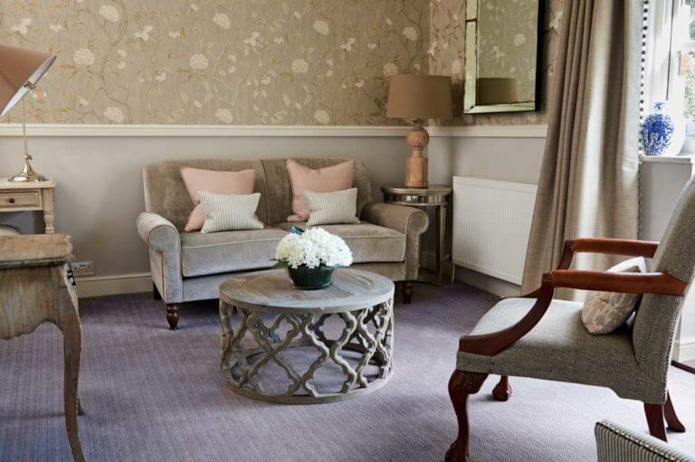 Hotel suite lounge area with neutral decor, white flowers on coffee table
