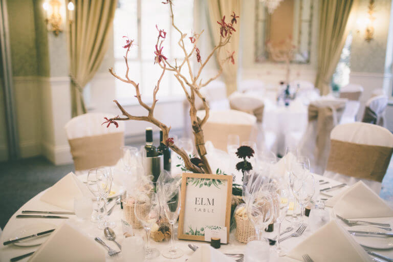 Wedding breakfast table set with tree branch sculpture as centrepiece 