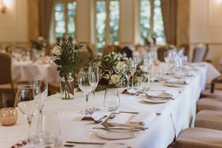 Table set for wedding breakfast with flowers as a centrepiece
