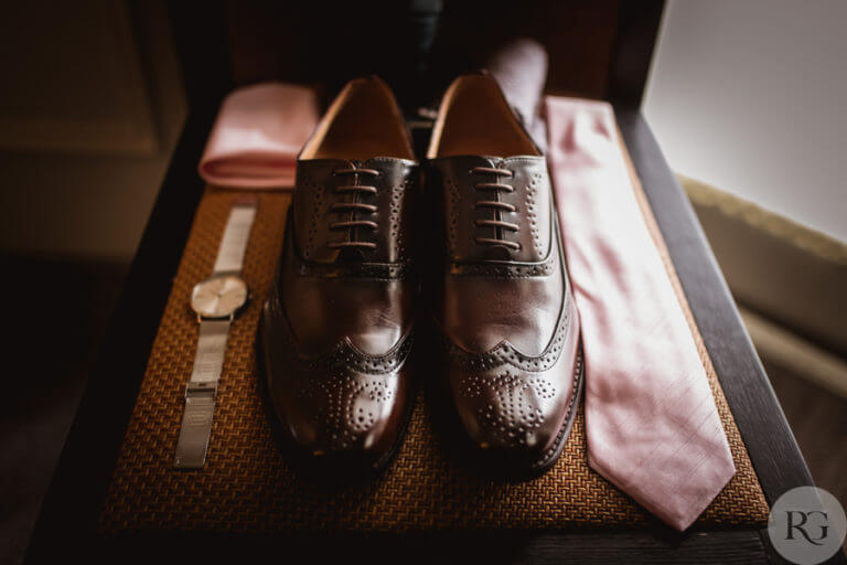 Close up of groom's wedding day shoes and accessories - brown leather shoes, watch, tie and handkerchief 