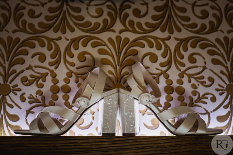 Bride's wedding heels against a patterned wallpaper