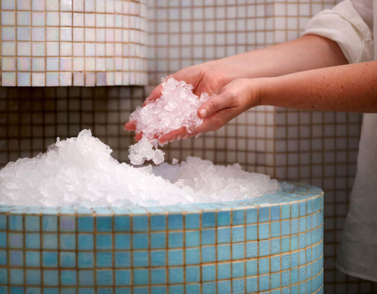 A spa-goes at SenSpa scooping up crushed ice from within the ice-room.