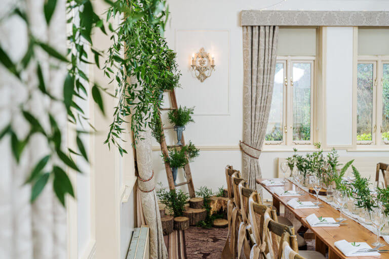 Long wooden tables with foliage at Careys Manor Hotel & SenSpa