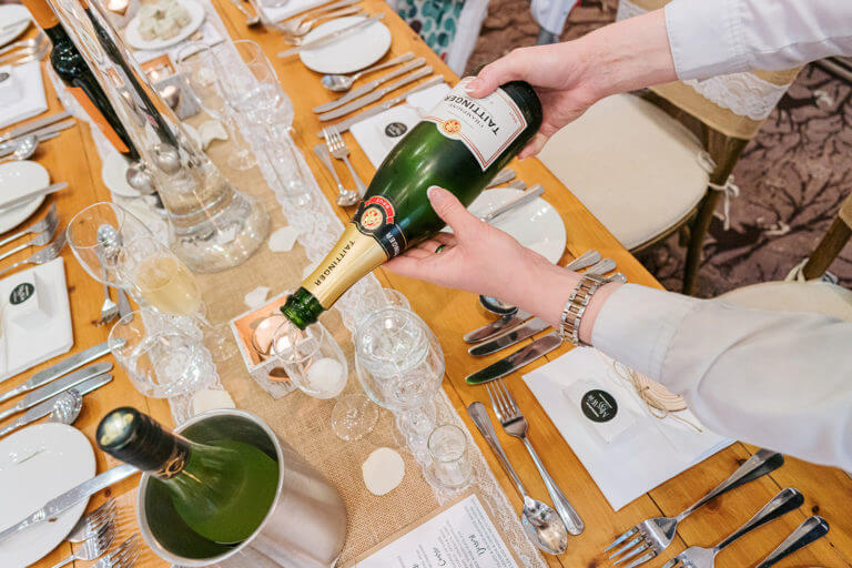 Pouring Champagne at a wedding breakfast at Careys Manor