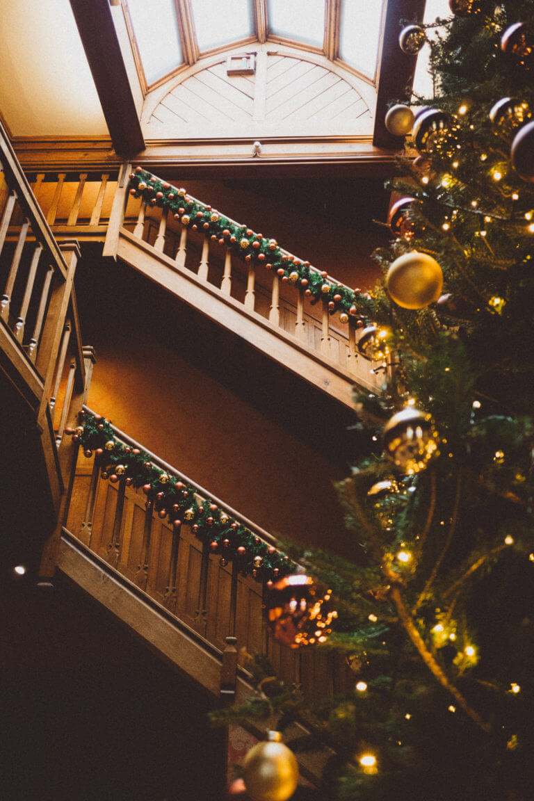 Christmas decorations up the oak staircase at Careys Manor