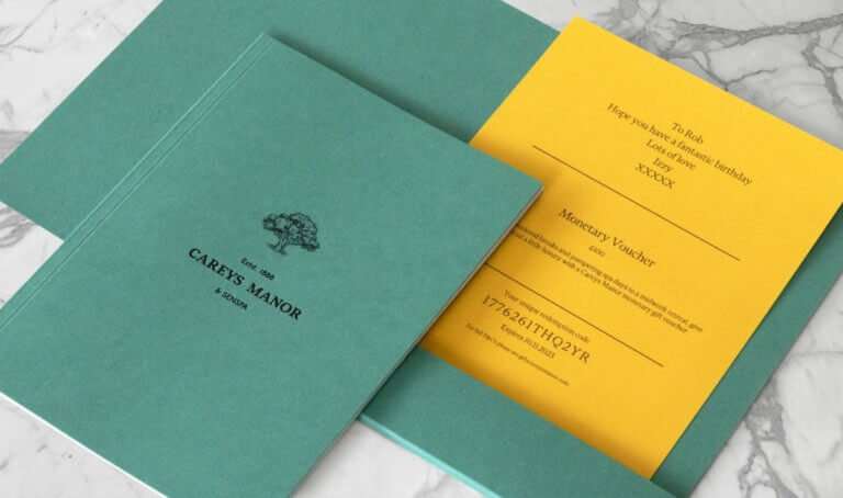 A green A5 brochure and wallet with a yellow gift voucher inside.