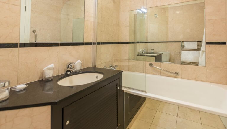 Basic bathroom in hotel with bath and sink
