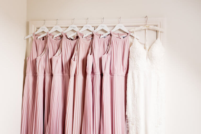 Bride and Bridesmaids dresses hanging on door frame at New Forest wedding venue Careys Manor Hotel