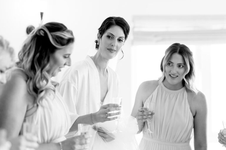 Black and white photo of bride getting ready with two friends