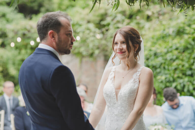 The Bride and Groom gaze at each other during the ceremony vows at Hampshire wedding venue Careys Manor Hotel