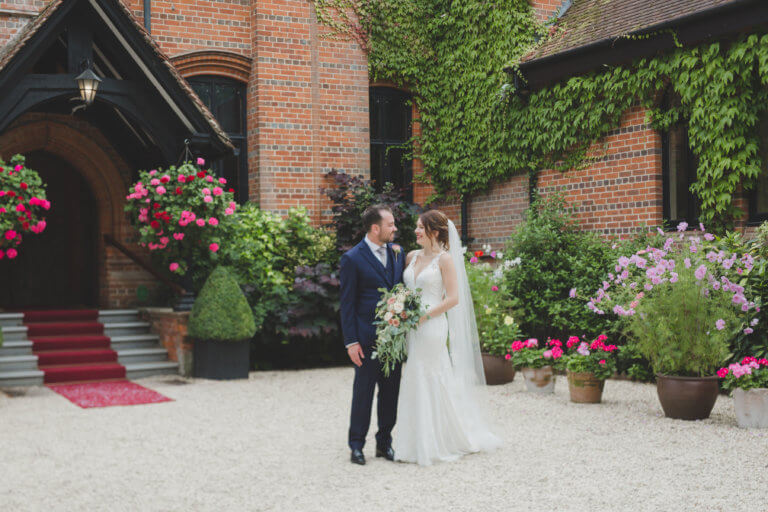 Bride and Groom stood outside Careys Manor Hotel, Hampshire wedding venue