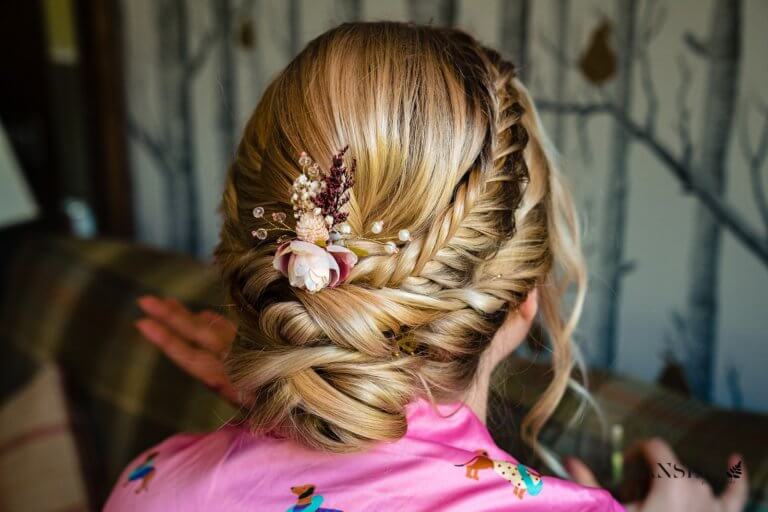 A rear view of one of the bridesmaids hair showing an up-do with flowers