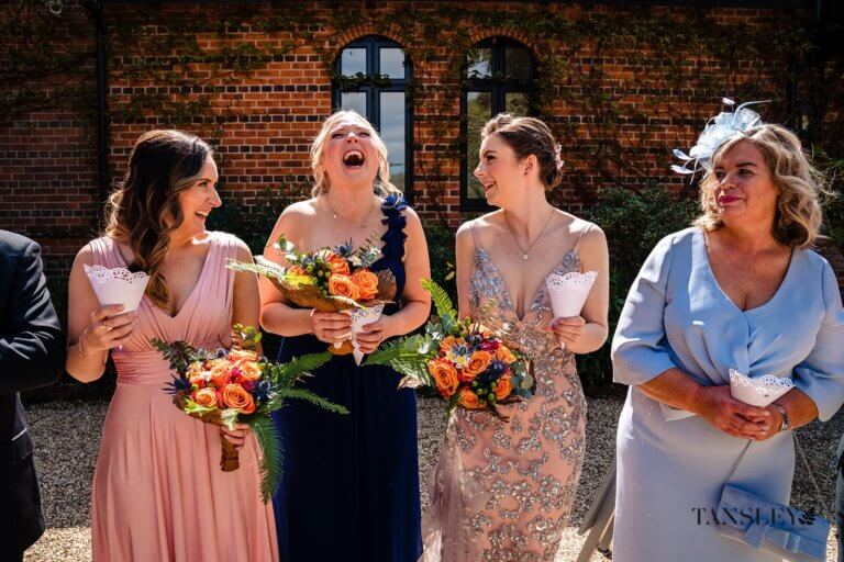 The Bridesmaids laugh awaiting the married couple for the confetti throwing
