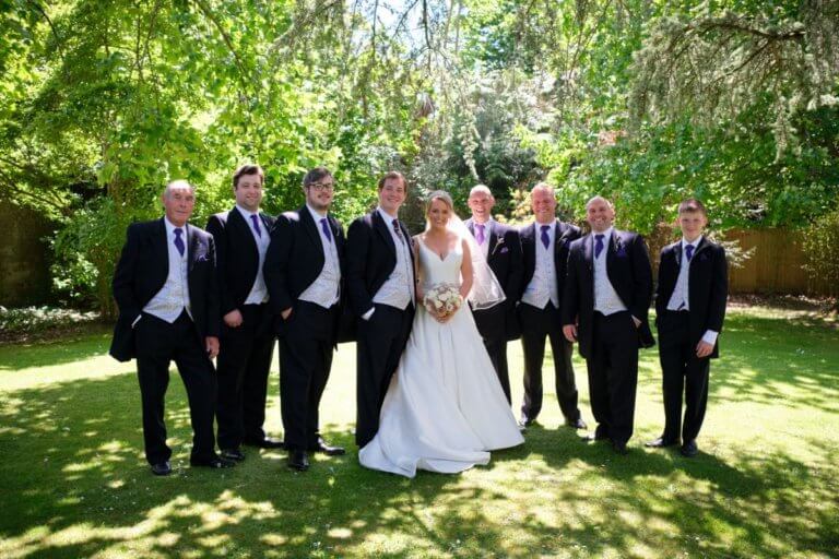 Bride and Groom pose in the gardens with the groomsmen