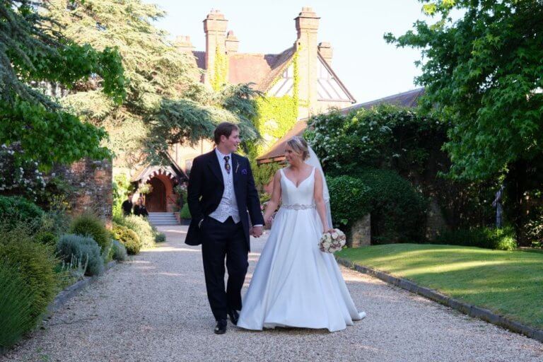 Bride and Groom walk up the hotel drive gazing at each other