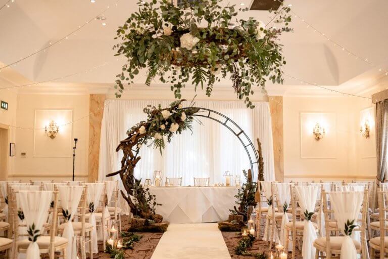 A close up of the floral hoop for the wedding ceremony with the registrats table