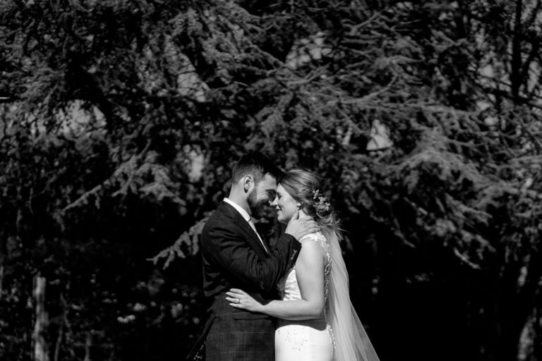 The bride and groom embrace in the garden
