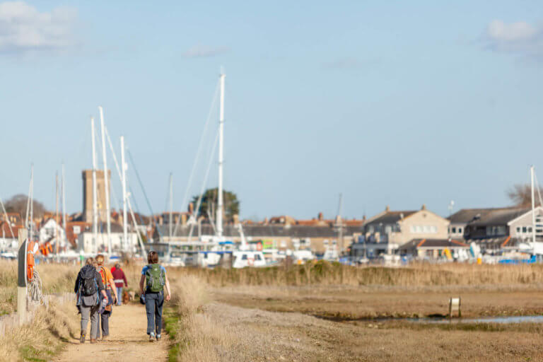 Group walking beside the harbour on the Isle of Wight