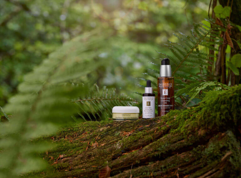 3 organic skincare products from Hungarian brand Eminence sitting within a woodland setting.