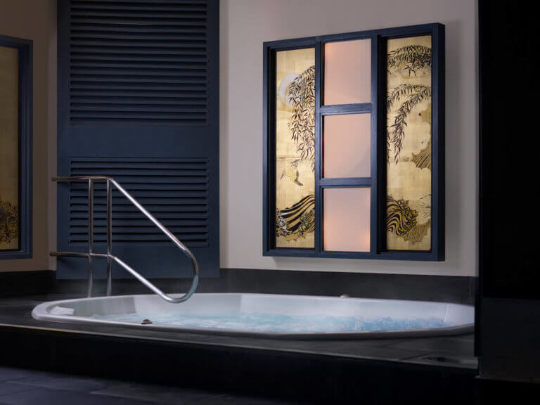 Jacuzzi at New Forest spa, SenSpa. The water is warm and bubbling and there is a gold Chinese mural on the wall behind.
