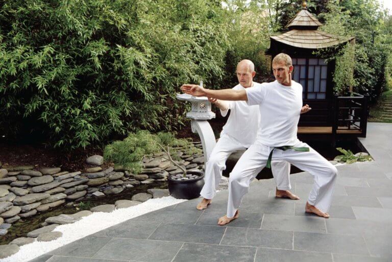 Two men dressed in white practice Tai Chi in Zen Garden courtyard garden inspired by Thailand