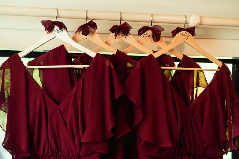 Deep red wedding dresses hanging on personalised hangers