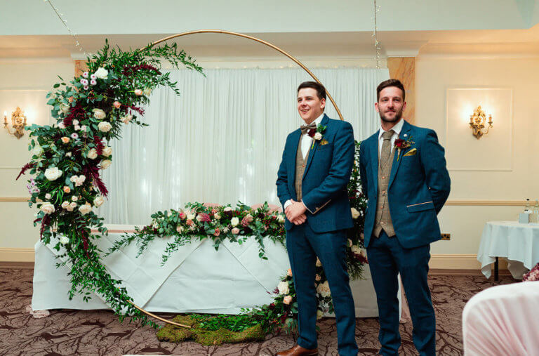 Groom and best man stand in front of the registrars table before the wedding ceremony