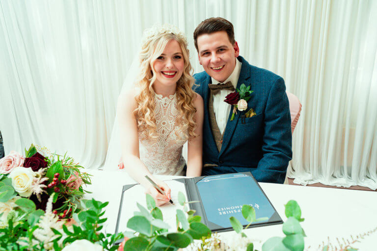 The bride & groom sign the register