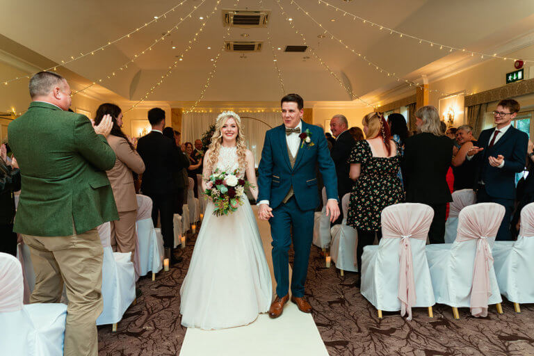 The bride and groom leave the ceremony as a married couple