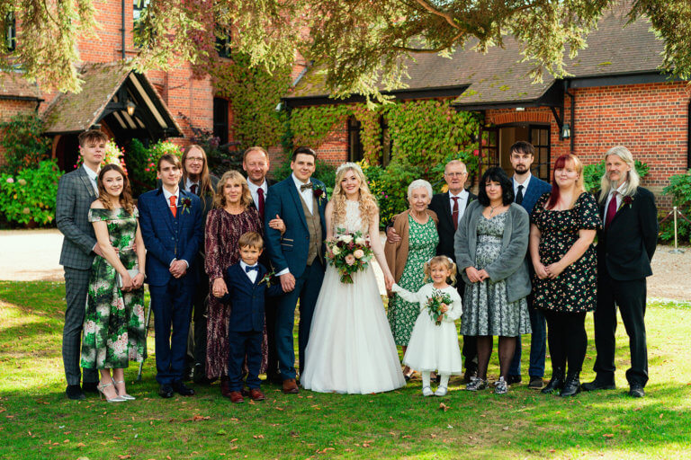The bride and groom pose with family and friends