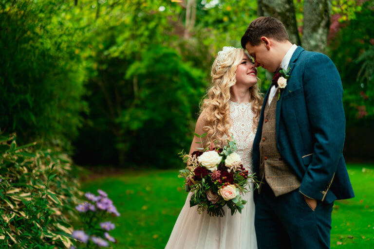 The couple lean in together and touch noses, smiling