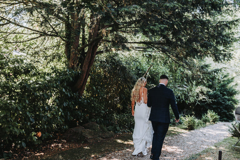 Bride and Groom hand in hand away from the camera