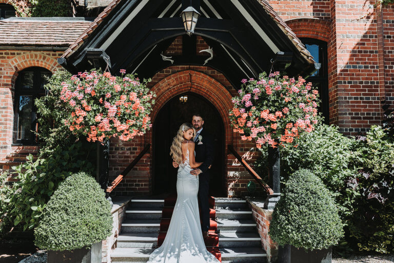 Bride and Groom pose in the main entrance to the hotel