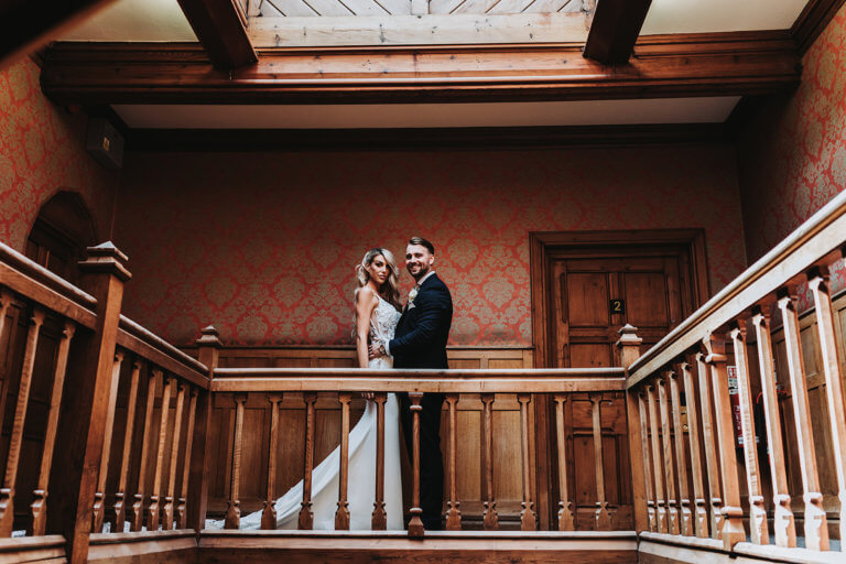 Bride and Groom pose at the top of the staircase