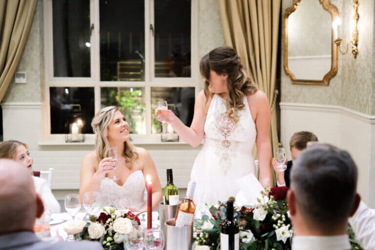The brides toast each other during the wedding breakfast