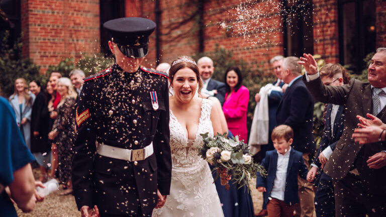 Confetti is thrown over the couple at the hotel entrance