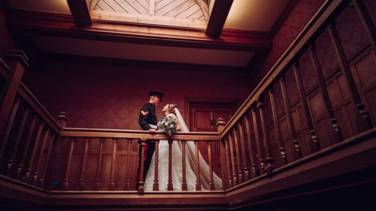 Bride and groom stand at the top of the stairs