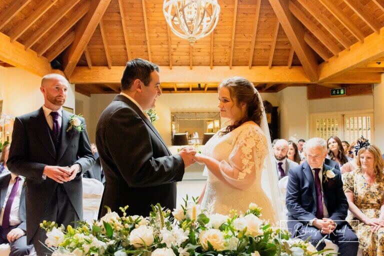 Bride and groom holding hands during wedding ceremony at Careys Manor Hotel & SenSpa