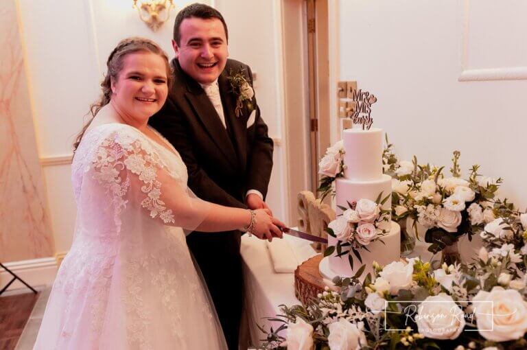 Bride and groom cut the cake at Careys Manor Hotel & SenSpa wedding