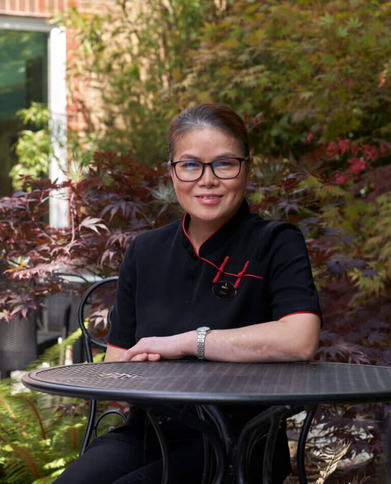 Spa therapist happily poses for photo in garden at SenSpa