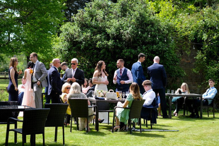 Guests mingle for drinks in the sunshine on the hotel lawns