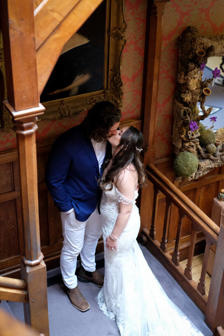 The bride and groom share a kiss on the stairs