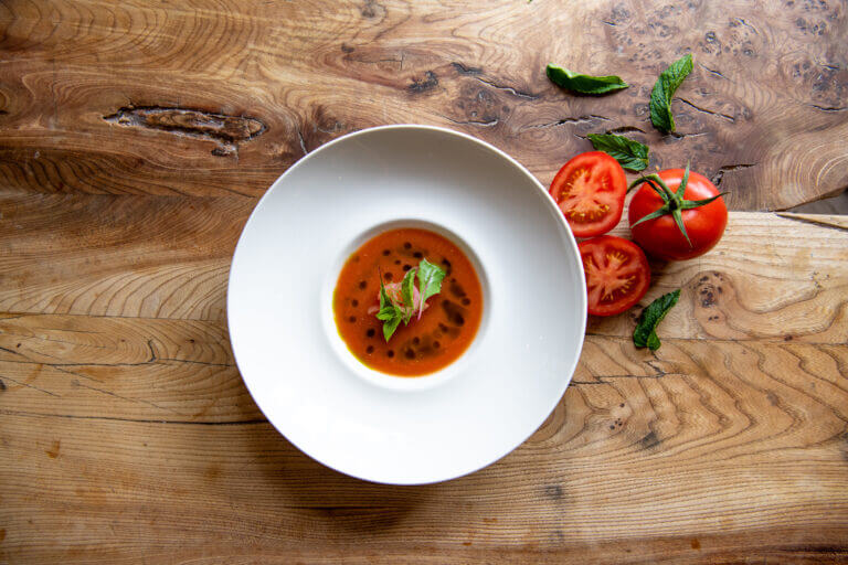 Fresh tomato soup dish served on wooden table