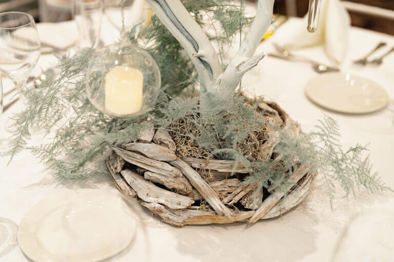 Winter wedding table setting at Careys Manor Hotel with candles and foliage